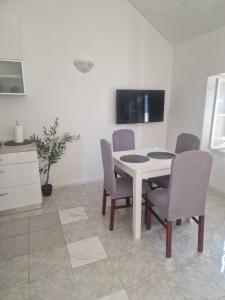 a dining room with a white table and chairs at Apartments Jelinek in Brela