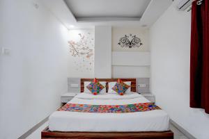 a bedroom with a large bed with colorful pillows at FabHotel Saanvi Paradise in Bhopal