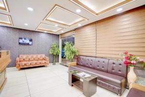 a waiting room with a couch and a table at FabHotel Saanvi Paradise in Bhopal