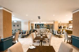ein Restaurant mit Tischen und Stühlen und einer Küche in der Unterkunft Santana Hotel & SPA in St Paul's Bay