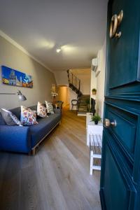 a living room with a blue couch and a staircase at Dimora l'Arancio in Lucca
