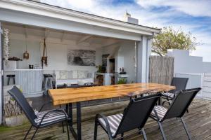 a patio with a wooden table and chairs at Alfred View in Port Alfred