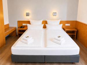 a large white bed in a room with two pillows at The Business Loft in Wolfsburg