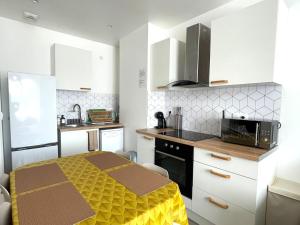 a small kitchen with a table and a microwave at Appartement Fleur De Houblon in Schiltigheim +9 photos