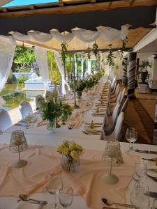 a long table with white tables and chairs at Riebeek Valley Hotel in Riebeek-Wes