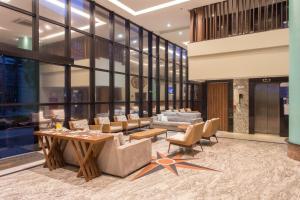a lobby with couches and a table and chairs at Hotel Brasil Tropical in Fortaleza
