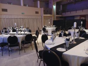 a group of tables with white table cloths and chairs at Riebeek Valley Hotel in Riebeek-Wes