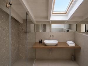 a bathroom with a sink and a glass shower at Neossiko Chios in Chios