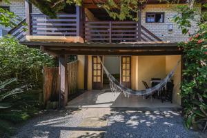 a house with a hammock in front of it at Hospedaria Nativa in Praia do Rosa