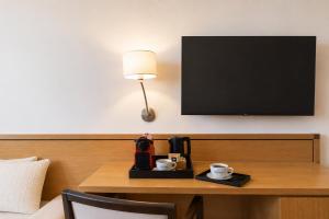 ein Hotelzimmer mit einem Tisch, einer Kaffeemaschine und einem Fernseher in der Unterkunft Hotel Duran in Figueres