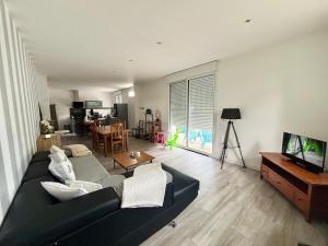 a living room with a black couch and a television at Casascope in Jaunay-Clan