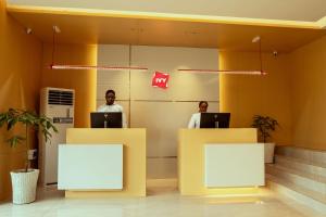 two men sitting in an office with their laptops at Ivy Hotel Lagos Ikeja in Hausa