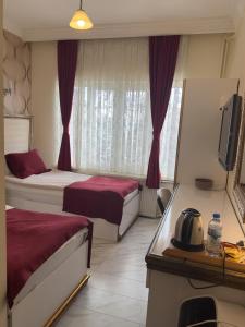 a hotel room with two beds and a television at Otel Nisa in Nevşehir