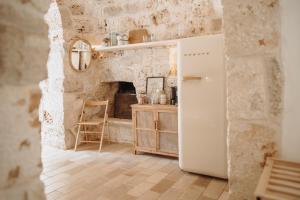 a kitchen with a white refrigerator in a room at Trullo Serenità Charming Trullo with Private Pool in Apulië in Ceglie Messapica