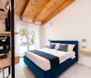 a bedroom with a blue bed and a window at Casa Madrigale - radici e ritorni in Praia a Mare