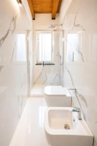 a white bathroom with a toilet and a sink at Casa Madrigale - radici e ritorni in Praia a Mare