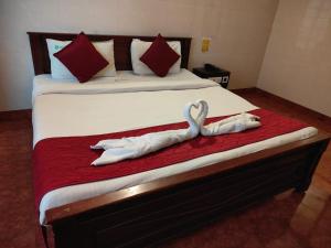 a bed with two swans laying on it at Klite stays - ZomoHotels in Pondicherry +4 photos