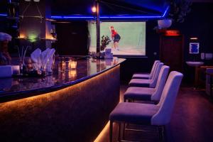 a bar with chairs and a video screen in a room at Klite stays - ZomoHotels in Pondicherry