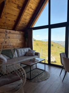 a living room with a couch and a table at Javorje Eco Cabin in Kolašin +5 photos