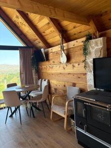 a living room with a table and chairs and a television at Javorje Eco Cabin in Kolašin