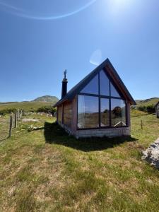 a small cabin with large windows on a grass field at Javorje Eco Cabin in Kolašin