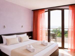 a bedroom with two beds and a large window at Silistar Hotel in Rezovo