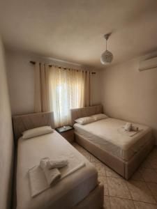 a bedroom with two beds and a window at Villa Kena in Ksamil