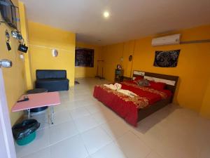 a bedroom with a red bed and a desk at ภูมิคิมมินทร์ รีสอร์ท & สปา in Ban Chai Na