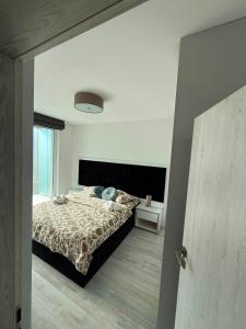 a bedroom with a bed with a comforter at RTS Residence in Baia Mare