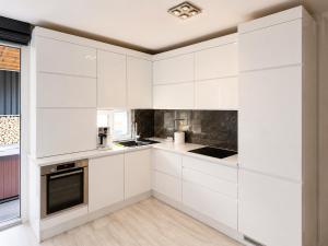 a white kitchen with white cabinets at RTS Residence in Baia Mare