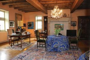 a living room with a table and chairs and a chandelier at Manoir de Malfarat in Charlieu