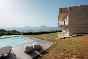 a house with a swimming pool next to a building at Boomerang Villa in Patra