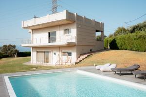 a house with a swimming pool in front of a house at Boomerang Villa in Patra