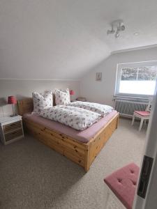 a bedroom with a wooden bed and a window at Casa LuVilla in Braunlage
