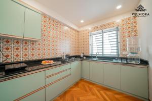 a kitchen with white cabinets and a window at Velmora Luxe Residences in Madurai