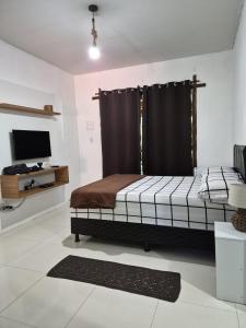 a bedroom with a bed and a television in it at Pousada Encanto do Mutá in Barra Grande