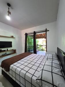 a bedroom with a bed and a large window at Pousada Encanto do Mutá in Barra Grande