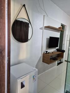 a room with a television and a mirror on the wall at Pousada Encanto do Mutá in Barra Grande +16 photos