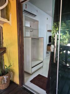 a kitchen with a white refrigerator in a room at Pousada Encanto do Mutá in Barra Grande