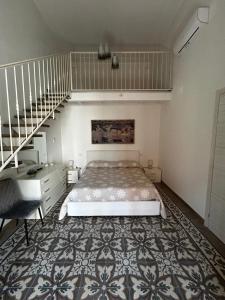 ein Schlafzimmer mit einem Bett und einer Treppe in der Unterkunft Li Cafari in Aradeo