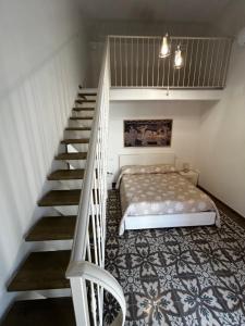 eine Treppe in einem Schlafzimmer mit einem Bett und einer Treppe in der Unterkunft Li Cafari in Aradeo
