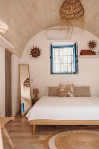 a bedroom with a large bed and a window at Trullo Serenità Charming Trullo with Private Pool in Apulië in Ceglie Messapica +32 photos