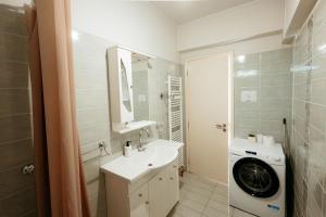 a bathroom with a sink and a washing machine at Boomerang Villa in Patra +13 photos
