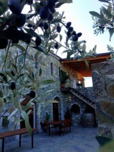 a stone building with a table and chairs and a tree at Kulla Zefit Agritourism in Hajmel