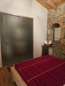 a large sliding door in a room with a stone wall at Kulla Zefit Agritourism in Hajmel
