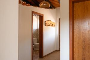 a hallway with a toilet and a door to a bathroom at Vida Pura Guesthouse in Odeceixe