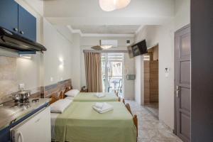 a kitchen with two tables with green table cloth at Bikakis Family Apartments in Kissamos