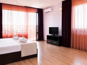 a hotel room with a bed and a television at Silistar Hotel in Rezovo
