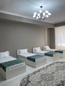 three beds sitting in a room with a rug at Парк апарт-отел in Namangan