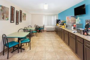 a restaurant with tables and chairs and a counter at Days Inn by Wyndham Charleston in Charleston